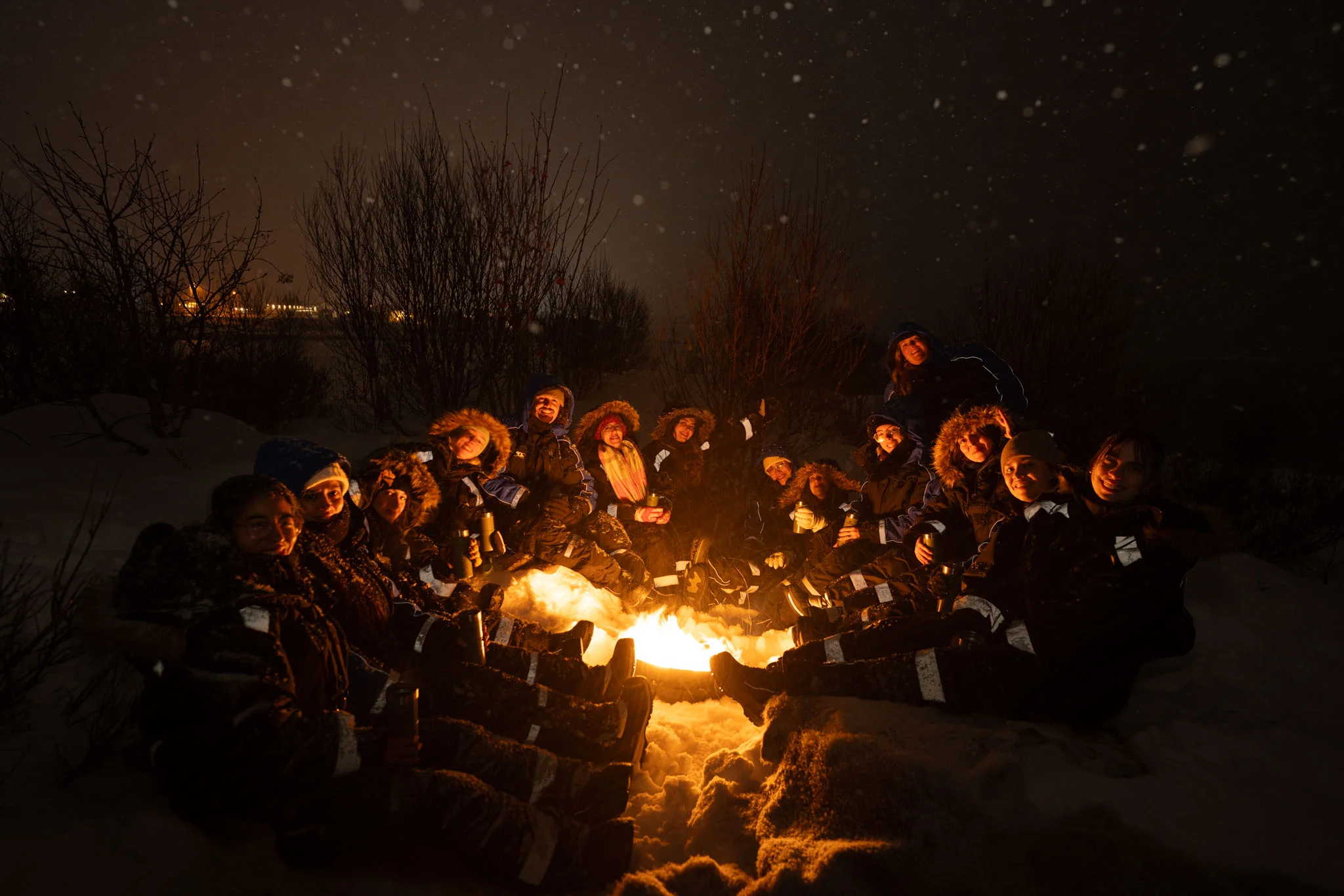 Grupo alrededor de la fogata en la nieve